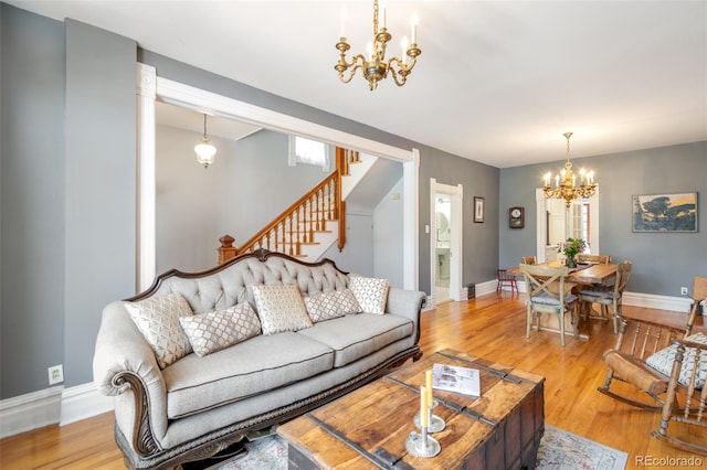 living room with an inviting chandelier and light hardwood / wood-style floors