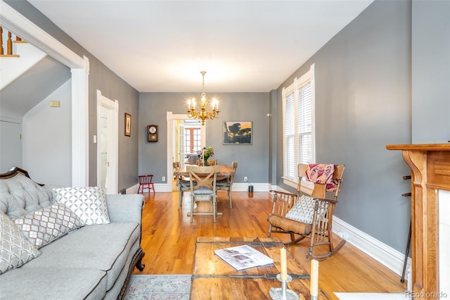 living room featuring a notable chandelier and light hardwood / wood-style flooring