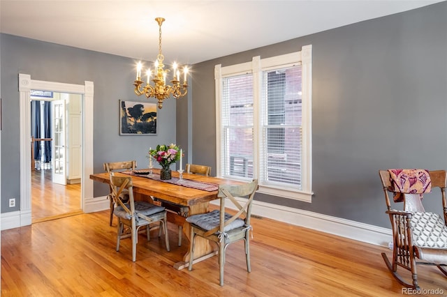 dining area with a chandelier and light hardwood / wood-style floors