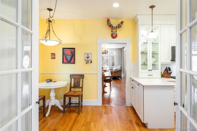 kitchen with pendant lighting, light hardwood / wood-style flooring, and white cabinets