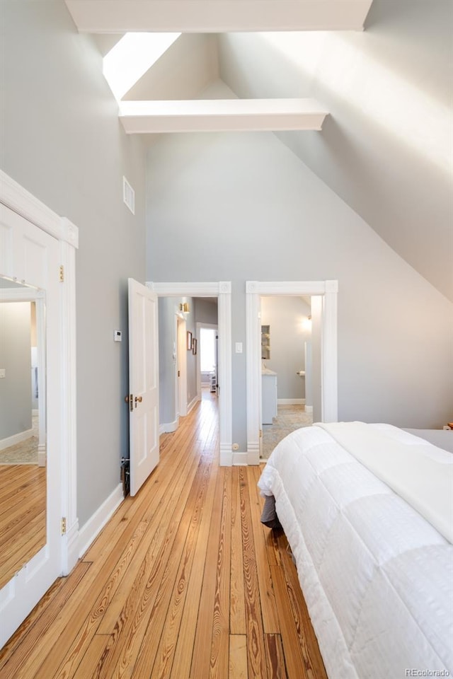 bedroom with high vaulted ceiling and light hardwood / wood-style flooring