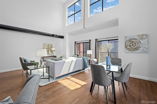 dining area featuring a high ceiling, plenty of natural light, and baseboards