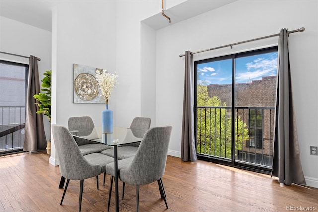 dining area with baseboards, wood finished floors, and a healthy amount of sunlight