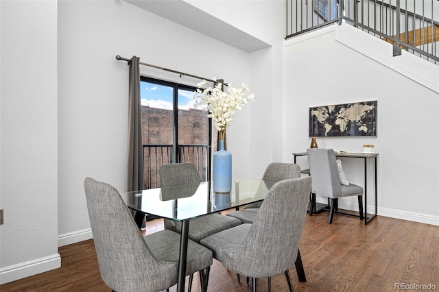 dining area with baseboards, stairs, wood finished floors, and an inviting chandelier