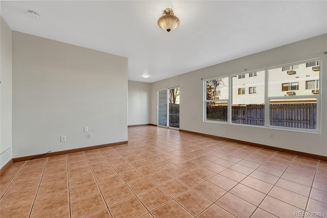 empty room featuring light tile patterned floors and baseboards