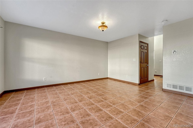 unfurnished room with baseboards, visible vents, and tile patterned floors