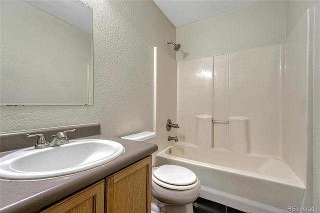 full bathroom with toilet, a textured wall, vanity, and shower / bathtub combination