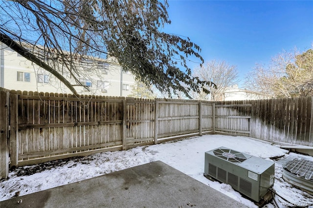 snow covered patio featuring a fenced backyard