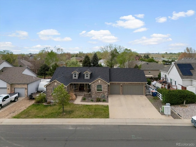 5708 Wetland Loop, Frederick, CO 80504 - view of front of house featuring an attached garage, a front lawn, stone siding, a porch, and driveway