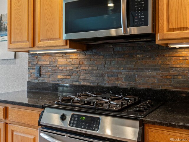 5708 Wetland Loop, Frederick, CO 80504 - kitchen featuring dark stone counters, appliances with stainless steel finishes, and tasteful backsplash