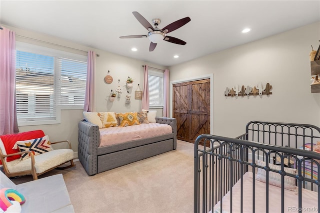 carpeted bedroom with ceiling fan and multiple windows