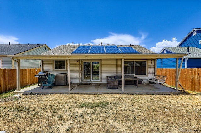 4932 Jasper St, Denver, CO 80239 - rear view of house with roof mounted solar panels, outdoor lounge area, a patio, and roof with shingles