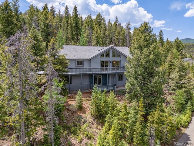 6882 Snowshoe Trl, Evergreen, CO 80439 - back of property featuring a view of trees and a balcony