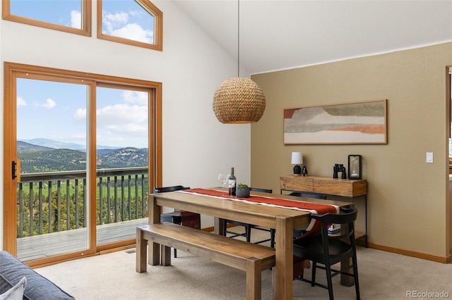 6882 Snowshoe Trl, Evergreen, CO 80439 - dining area with light colored carpet, a mountain view, and high vaulted ceiling