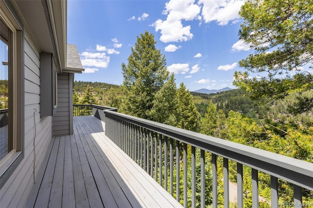 6882 Snowshoe Trl, Evergreen, CO 80439 - wooden deck featuring a view of trees and a mountain view
