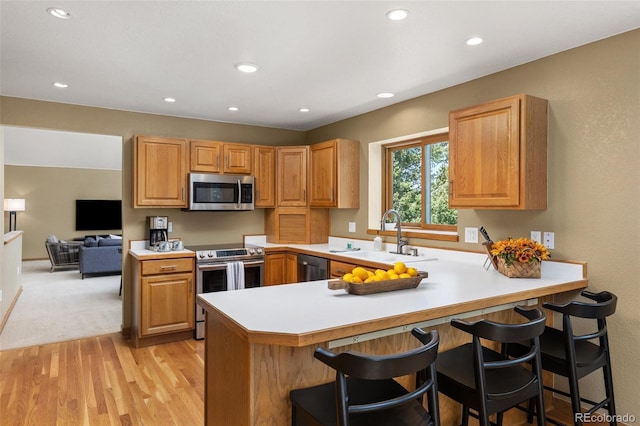 6882 Snowshoe Trl, Evergreen, CO 80439 - kitchen with stainless steel appliances, a kitchen breakfast bar, light countertops, a peninsula, and recessed lighting