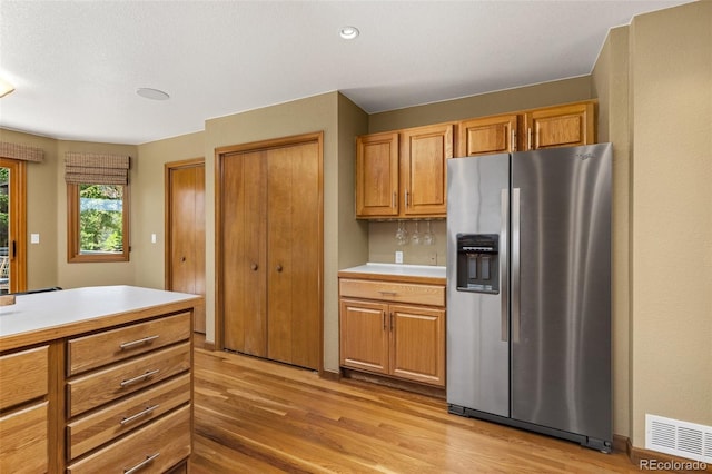 6882 Snowshoe Trl, Evergreen, CO 80439 - kitchen with stainless steel refrigerator with ice dispenser, light wood-style flooring, light countertops, brown cabinetry, and recessed lighting