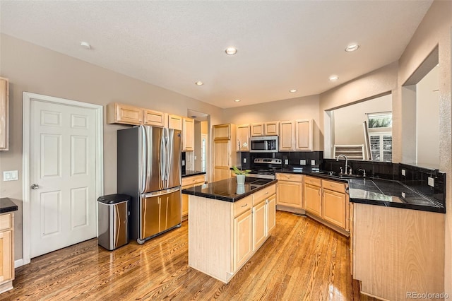 kitchen with sink, appliances with stainless steel finishes, a center island, light hardwood / wood-style floors, and light brown cabinetry