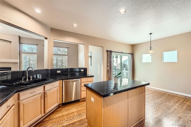 kitchen with light hardwood / wood-style flooring, a center island, a textured ceiling, light brown cabinetry, and stainless steel dishwasher