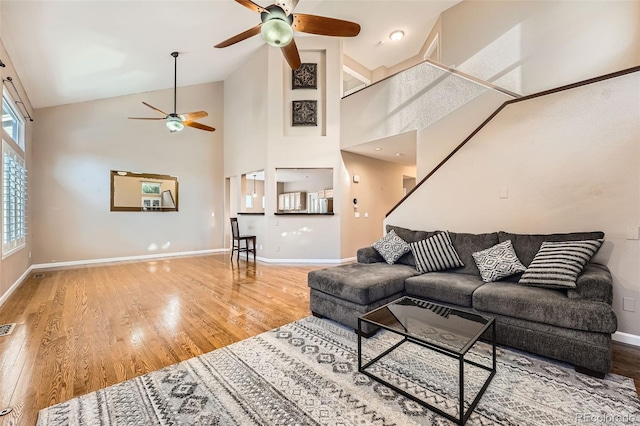 living room featuring hardwood / wood-style flooring, high vaulted ceiling, and ceiling fan