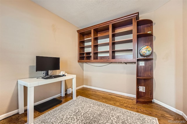 office area with hardwood / wood-style floors and a textured ceiling