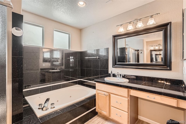 bathroom with vanity, separate shower and tub, and a textured ceiling