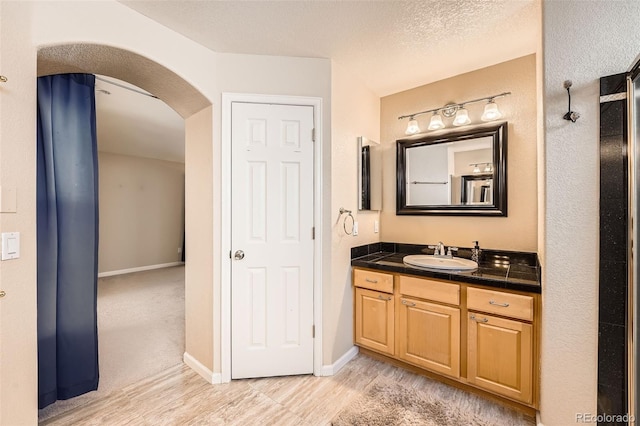 bathroom with vanity, hardwood / wood-style floors, and a textured ceiling