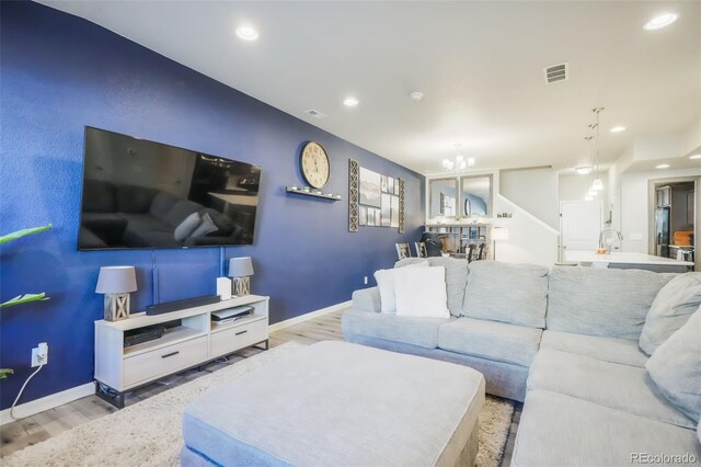 4026 Tiberias Pt, Colorado Springs, CO 80916 - living room featuring a notable chandelier and light hardwood / wood-style flooring