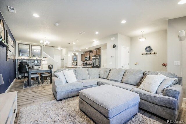 4026 Tiberias Pt, Colorado Springs, CO 80916 - living room with light hardwood / wood-style flooring and a chandelier
