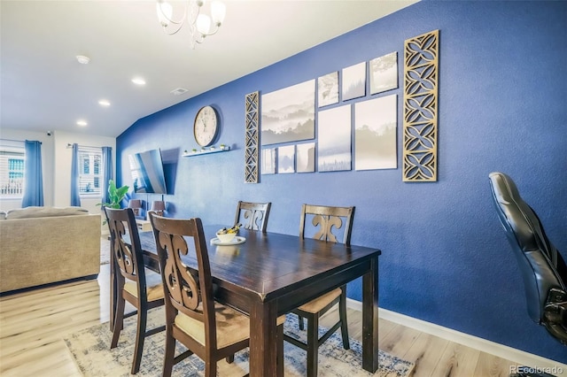 4026 Tiberias Pt, Colorado Springs, CO 80916 - dining space with light wood-type flooring, vaulted ceiling, and a notable chandelier