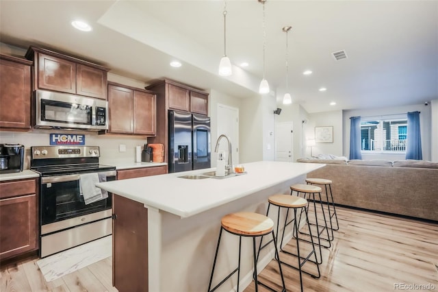 4026 Tiberias Pt, Colorado Springs, CO 80916 - kitchen featuring a kitchen breakfast bar, sink, stainless steel appliances, and a kitchen island with sink