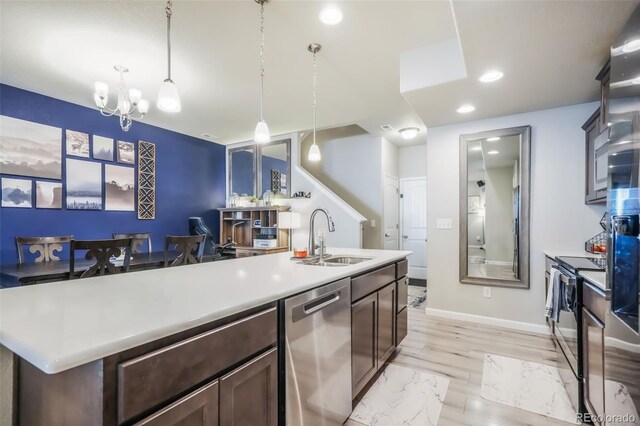 4026 Tiberias Pt, Colorado Springs, CO 80916 - kitchen featuring appliances with stainless steel finishes, sink, pendant lighting, a chandelier, and an island with sink