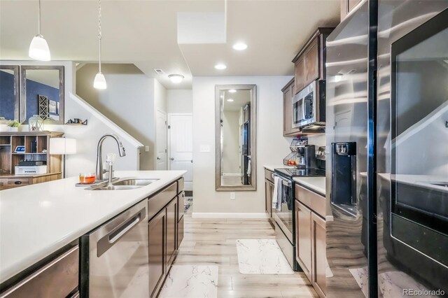 4026 Tiberias Pt, Colorado Springs, CO 80916 - kitchen featuring sink, stainless steel appliances, hanging light fixtures, and light hardwood / wood-style flooring