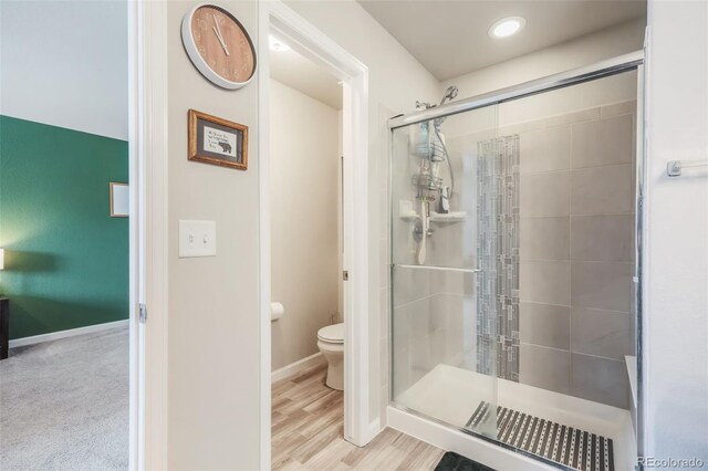 4026 Tiberias Pt, Colorado Springs, CO 80916 - bathroom featuring hardwood / wood-style floors, an enclosed shower, and toilet