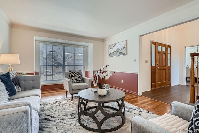 living area with crown molding, baseboards, and wood finished floors