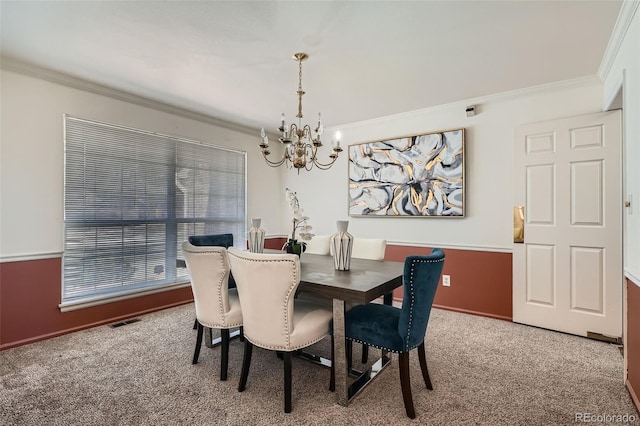 carpeted dining area featuring visible vents, a notable chandelier, and ornamental molding