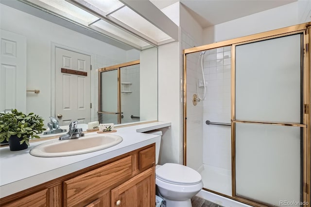 bathroom featuring a stall shower, vanity, and toilet