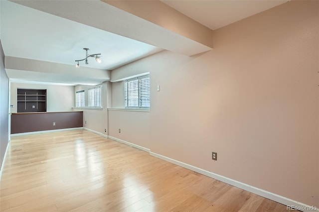 unfurnished room featuring light wood-style flooring and baseboards