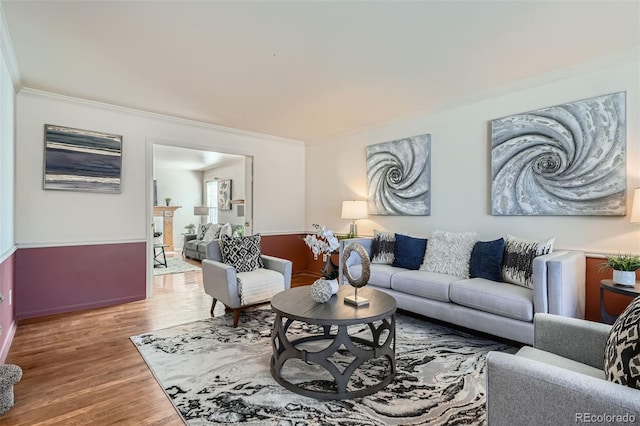 living room with ornamental molding and wood finished floors