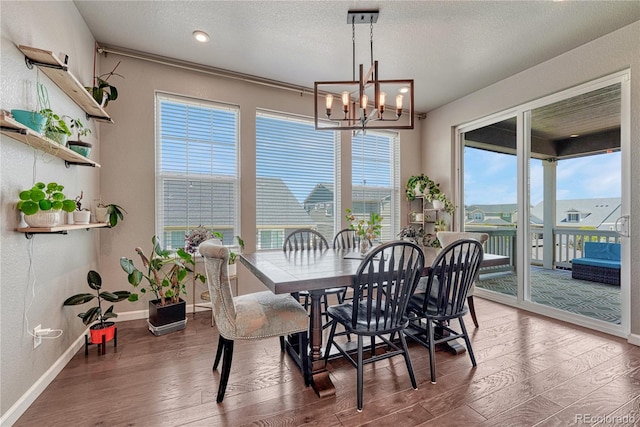 23957 E Rocky Top Ave, Aurora, CO 80016 - dining space with a chandelier, wood finished floors, and a textured ceiling
