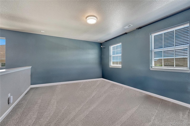 23957 E Rocky Top Ave, Aurora, CO 80016 - empty room featuring a textured ceiling, carpet flooring, and plenty of natural light