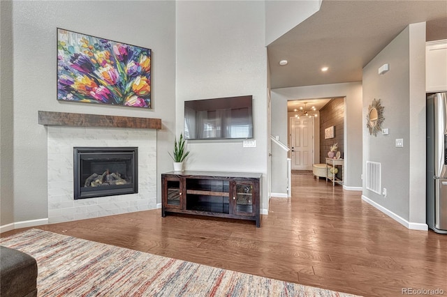 23957 E Rocky Top Ave, Aurora, CO 80016 - living area featuring wood finished floors, a chandelier, a tiled fireplace, and recessed lighting