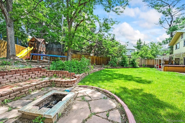 12625 W 66th Cir, Arvada, CO 80004 - view of yard with a trampoline, an outdoor fire pit, and a patio