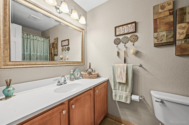 12625 W 66th Cir, Arvada, CO 80004 - bathroom featuring toilet, vanity, and a textured wall
