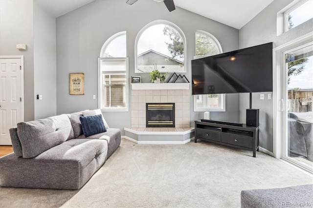 living room featuring carpet, a fireplace, ceiling fan, and vaulted ceiling with beams