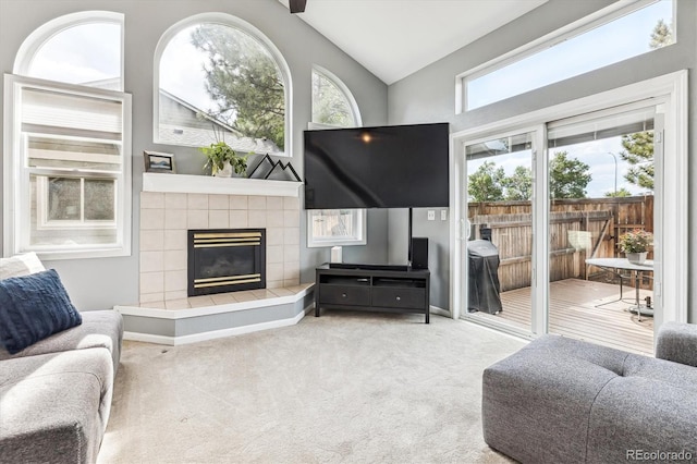 living room with lofted ceiling, a fireplace, and light carpet