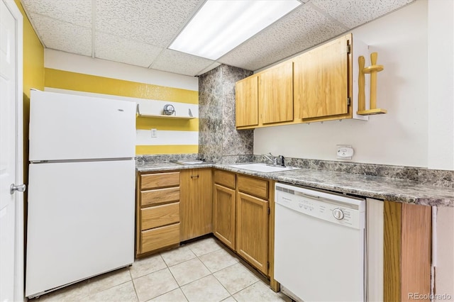 kitchen featuring white appliances, a drop ceiling, light tile patterned floors, and sink