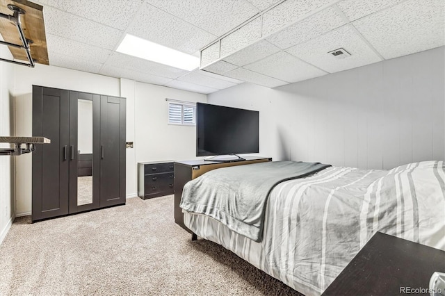 bedroom with carpet floors and a drop ceiling