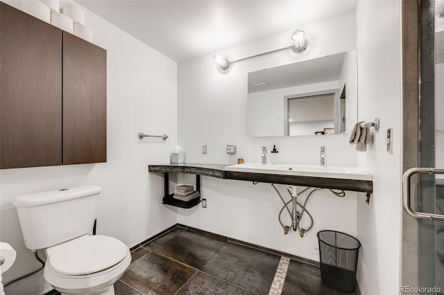 2801 Lawrence St, Denver, CO 80205 - bathroom featuring toilet, a sink, baseboards, and an enclosed shower