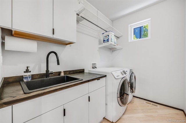 2801 Lawrence St, Denver, CO 80205 - laundry area with washer and clothes dryer, cabinet space, and light wood-style floors